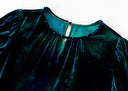 Detail of the blue dress’s gathered neckline and small decorative accents