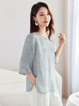Model wearing a light blue silk-blend New Chinese style top with a round neckline, paired with white trousers.