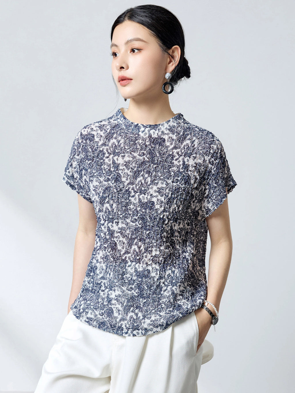 Side view of a blue and white printed silk top, showcasing the comfortable drape, bubble crepe texture, and versatile relaxed fit.