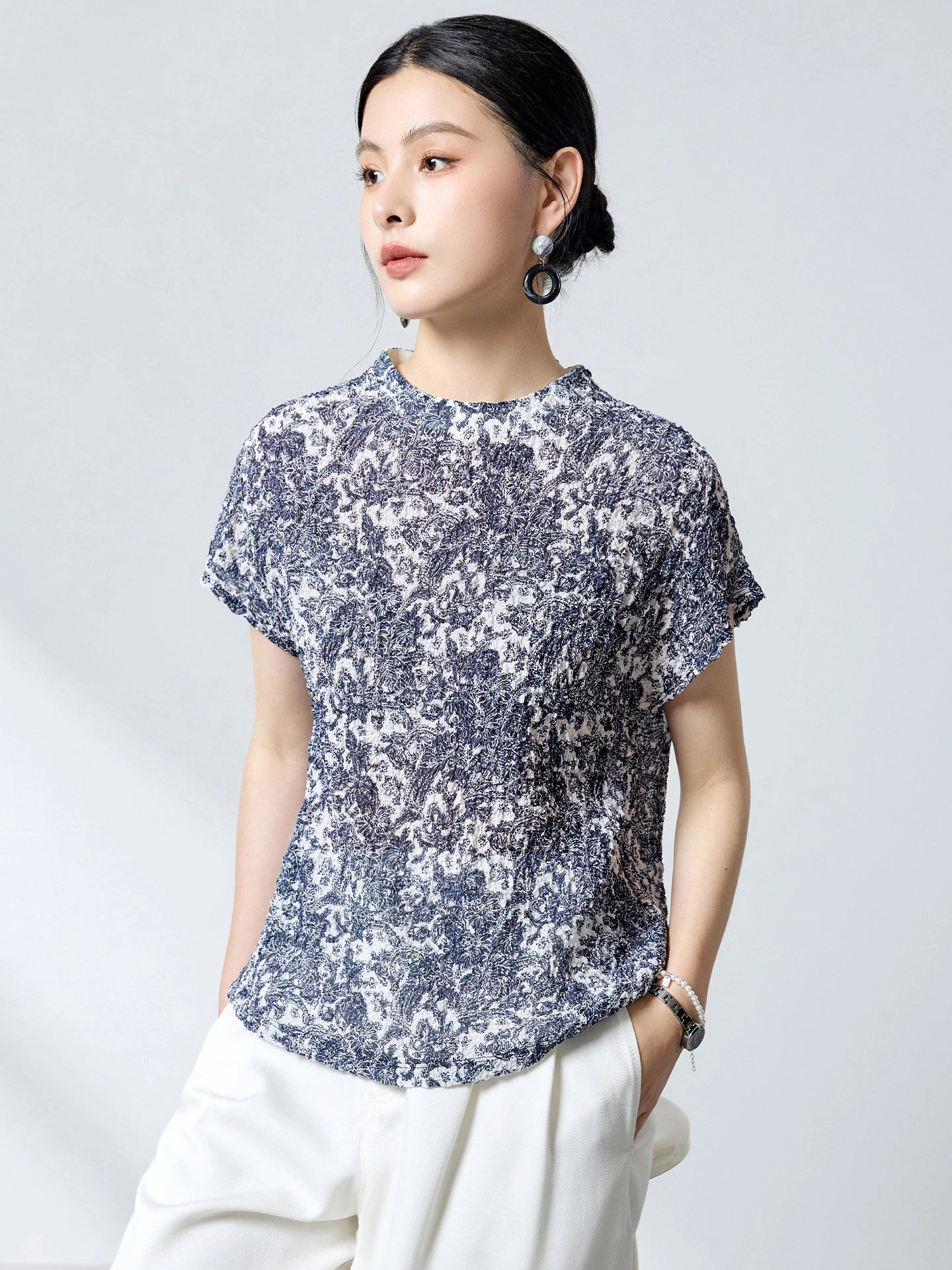 Side view of a blue and white printed silk top, showcasing the comfortable drape, bubble crepe texture, and versatile relaxed fit.