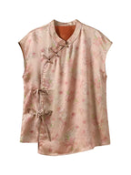 Front product view of a blush-pink Xiangyunsha silk sleeveless top with floral print, asymmetric closures and side bow ties