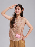 Woman wearing a blush floral Xiangyunsha silk sleeveless top with side ties and a relaxed silhouette