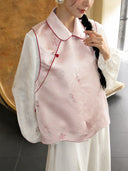 Close-up of the blush pink mulberry silk vest showing its turn-down collar, red piping, knot closure, and delicate pattern.