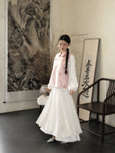 Full-body styling of a blush pink Songjin silk vest paired with a flowing white skirt.