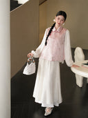 Model wearing a blush pink Songjin silk Chinese vest with a rounded turn-down collar and delicate butterfly motifs.