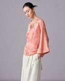 Side view of the blush pink floral jacquard blouse showing its relaxed straight fit