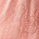Close-up of the lustrous blush pink jacquard fabric with woven floral and lattice motifs