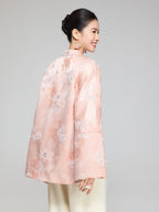 Back view of a blush pink wool and silk padded jacket showing the floral jacquard pattern and longer back hem