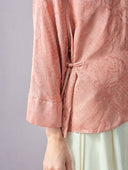 Close-up of the side fastening and wide three-quarter sleeve on the blush pink jacquard blouse