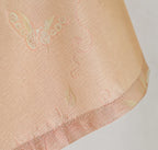 Close-up of the butterfly and floral jacquard pattern at the three-quarter sleeve hem