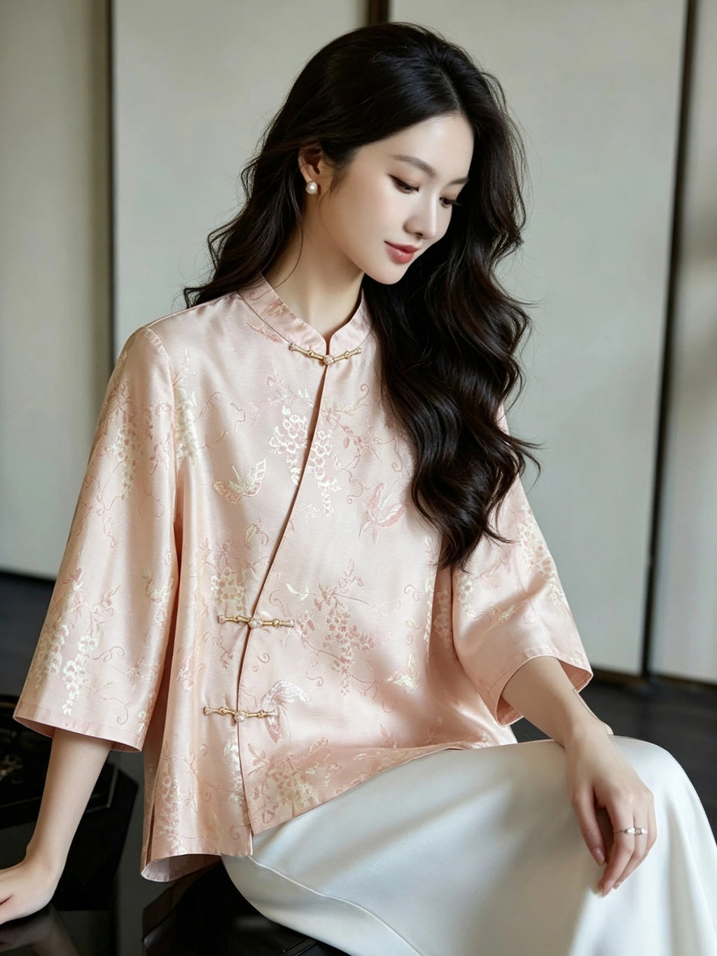 Woman wearing a blush pink Mandarin-collar silk blouse with botanical jacquard and wide three-quarter sleeves