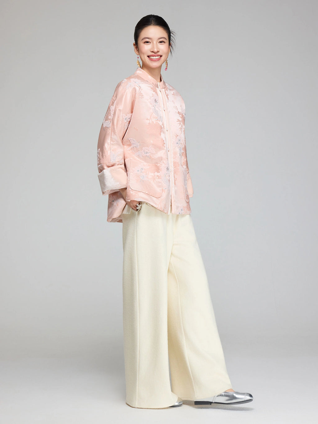 Side view of a blush pink Chinese-inspired padded jacket with wide sleeves and a relaxed straight fit