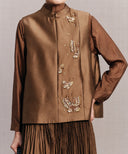 Close-up of the bronze brown vest’s embellished butterflies and concealed front panel