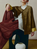 Model wearing a bronze Chinese-style jacket with a luminous finish and contrasting golden cuffs.