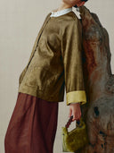 Side view of a bronze silk-blend Chinese jacket with a relaxed silhouette, round neck and contrast cuffs.