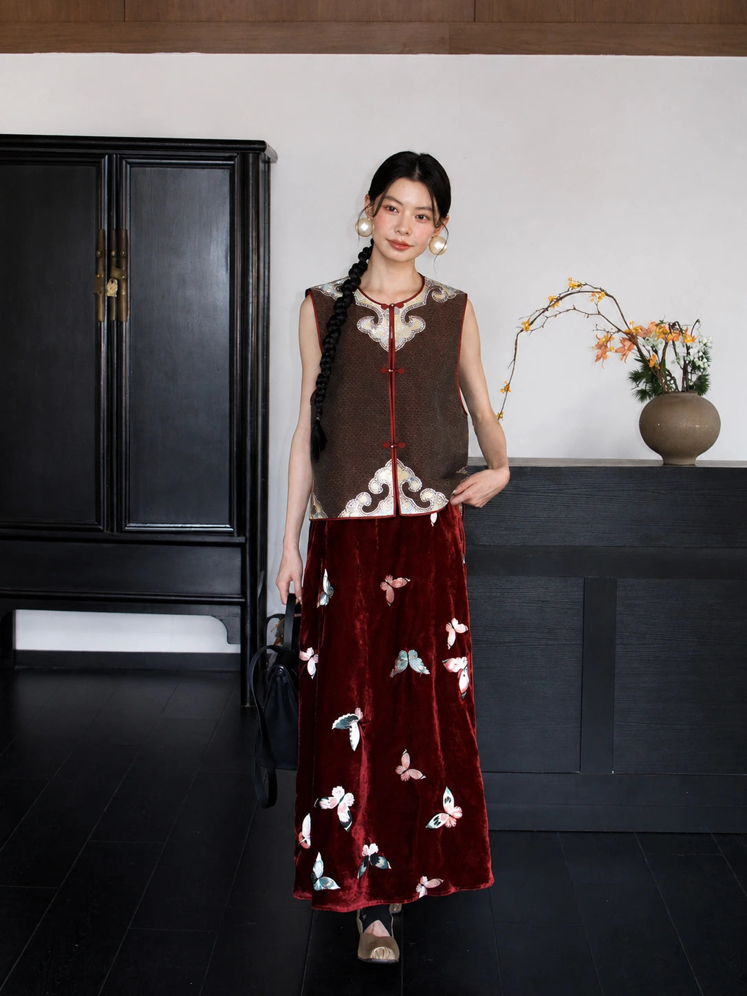 Full-body view of a brown 100% mulberry silk Chinese vest styled with a burgundy embroidered skirt.