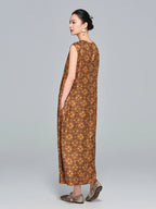Side view of a brown silk sleeveless A-line dress with a round neckline, relaxed fit, and side pockets, paired with flat shoes.