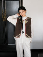 Front view of a brown Songjin silk vest featuring a round neckline, traditional frog closures, and decorative gold panels.