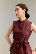 Close-up of a burgundy Qipao-style vest top with a mandarin collar, gold-toned buttons, and decorative contrast stitching, highlighting the premium silk material.
