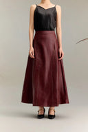 Full body shot of a burgundy leather-look vest top and A-line skirt set, featuring contrast stitching and a mandarin collar, crafted from 100% silk.