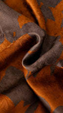 Close-up of the Burnt Orange and grey-purple floral print on draped silk fabric