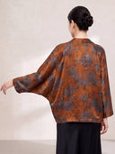 Back view of the Burnt Orange jacket showing the floral print and batwing sleeve shape