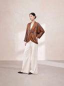Full-length styling view of the floral silk jacket with white wide-leg trousers