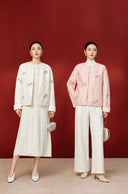 Beige and pink butterfly embroidered jackets shown side by side on models wearing white outfits.