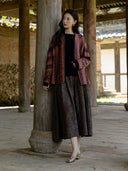 Full-length view of the model wearing the relaxed Canglan jacket with a black top and long gray skirt.