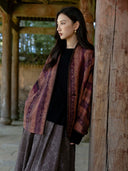 Three-quarter view of the Canglan jacket showing the rust and plum pattern, button closure and embroidered front edge.