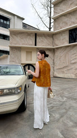 Back view of a caramel brown sleeveless Cheongsam top, showcasing the relaxed fit and jacquard texture, matched with white flowy pants.