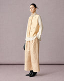 Side view of the champagne beige wool-silk vest layered over an ivory blouse