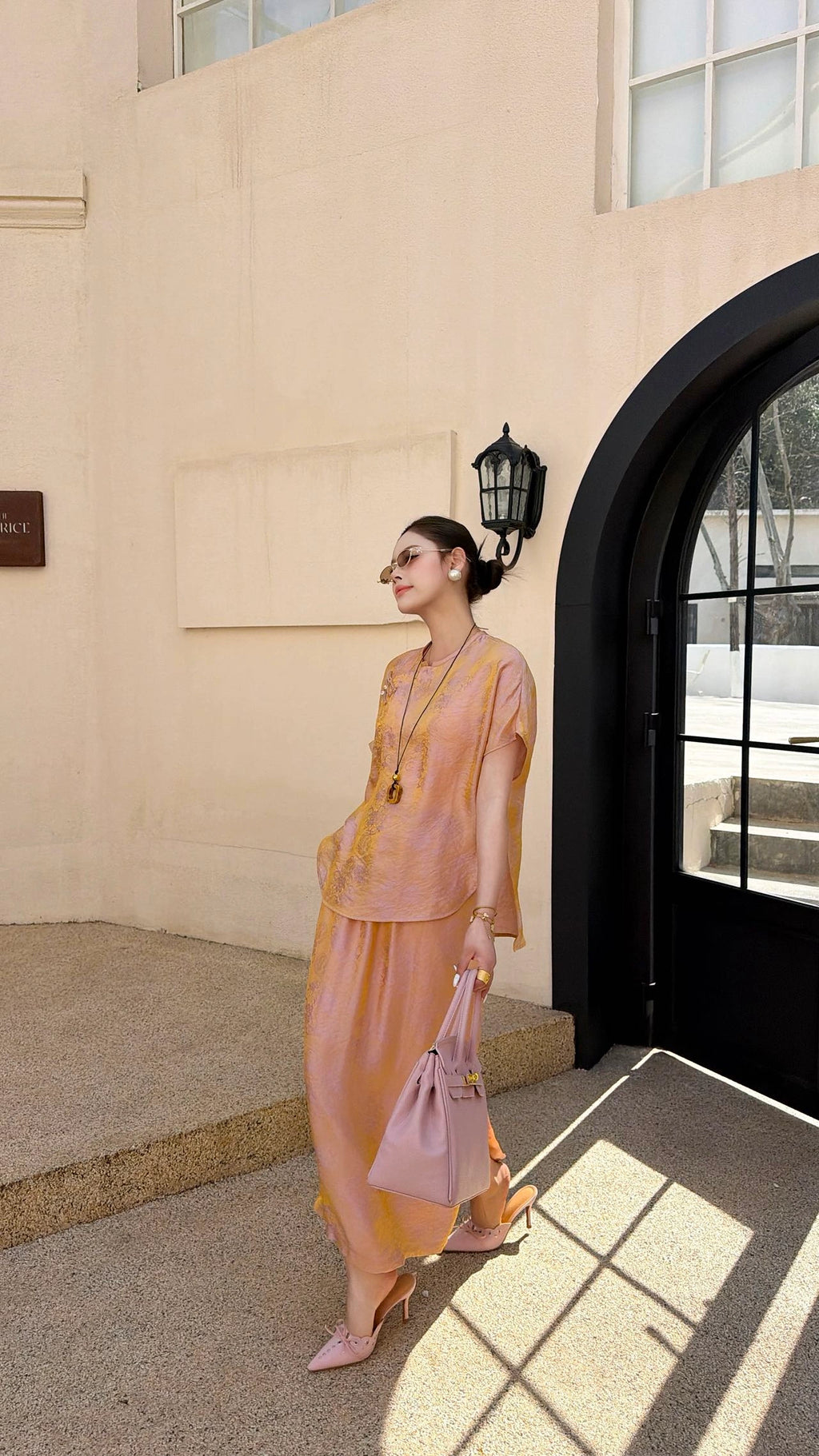 Side view of a champagne gold New Chinese style co-ord set, highlighting the subtle jacquard texture and side slit detail on the maxi skirt.