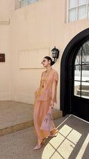 Side view of a champagne gold New Chinese style co-ord set, highlighting the subtle jacquard texture and side slit detail on the maxi skirt.