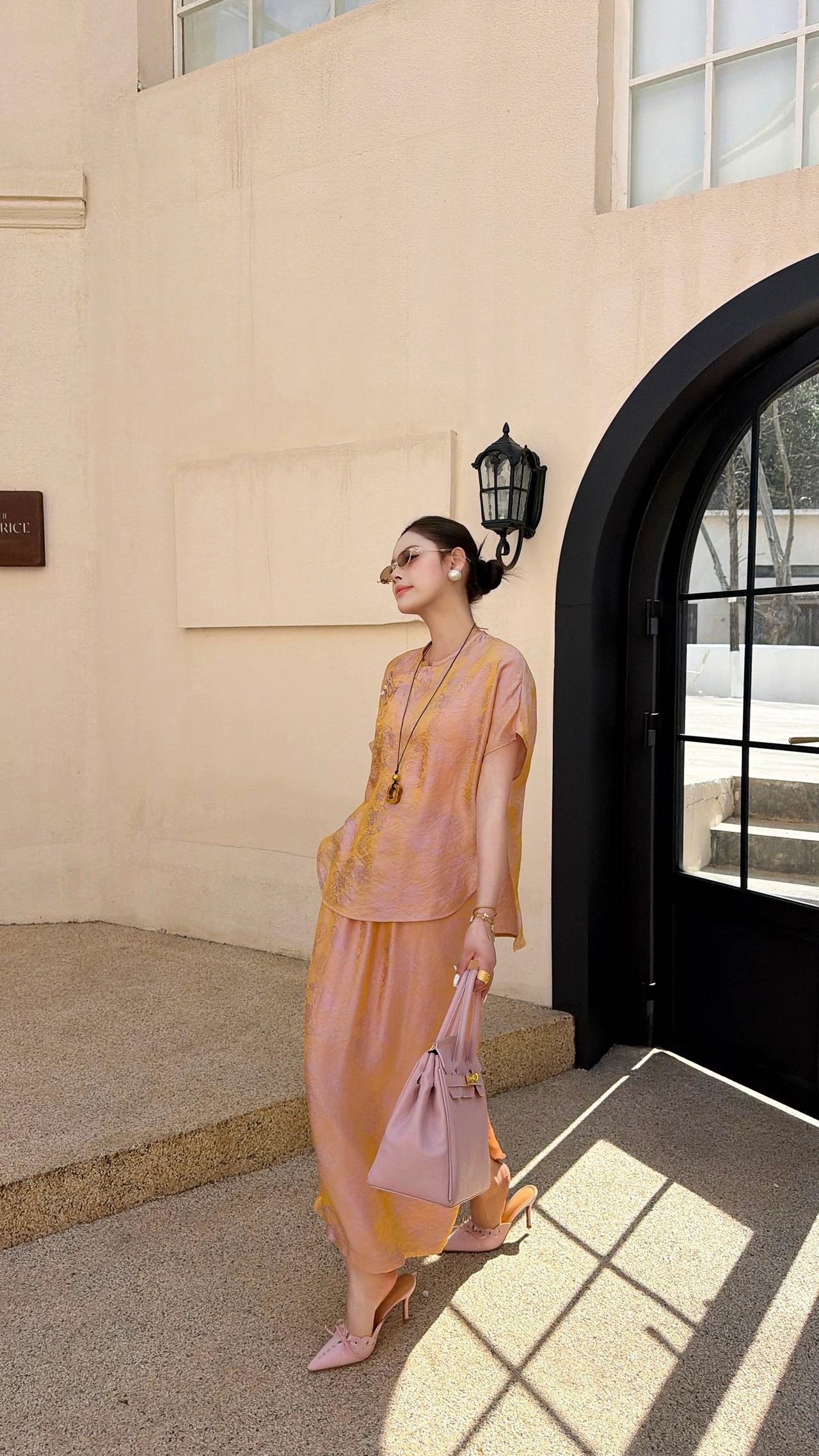 Side view of a champagne gold New Chinese style co-ord set, highlighting the subtle jacquard texture and side slit detail on the maxi skirt.