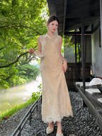 Side view of a champagne gold embroidered vest and skirt set, showcasing the scalloped lace hem and intricate beadwork, styled with pearl shoes.