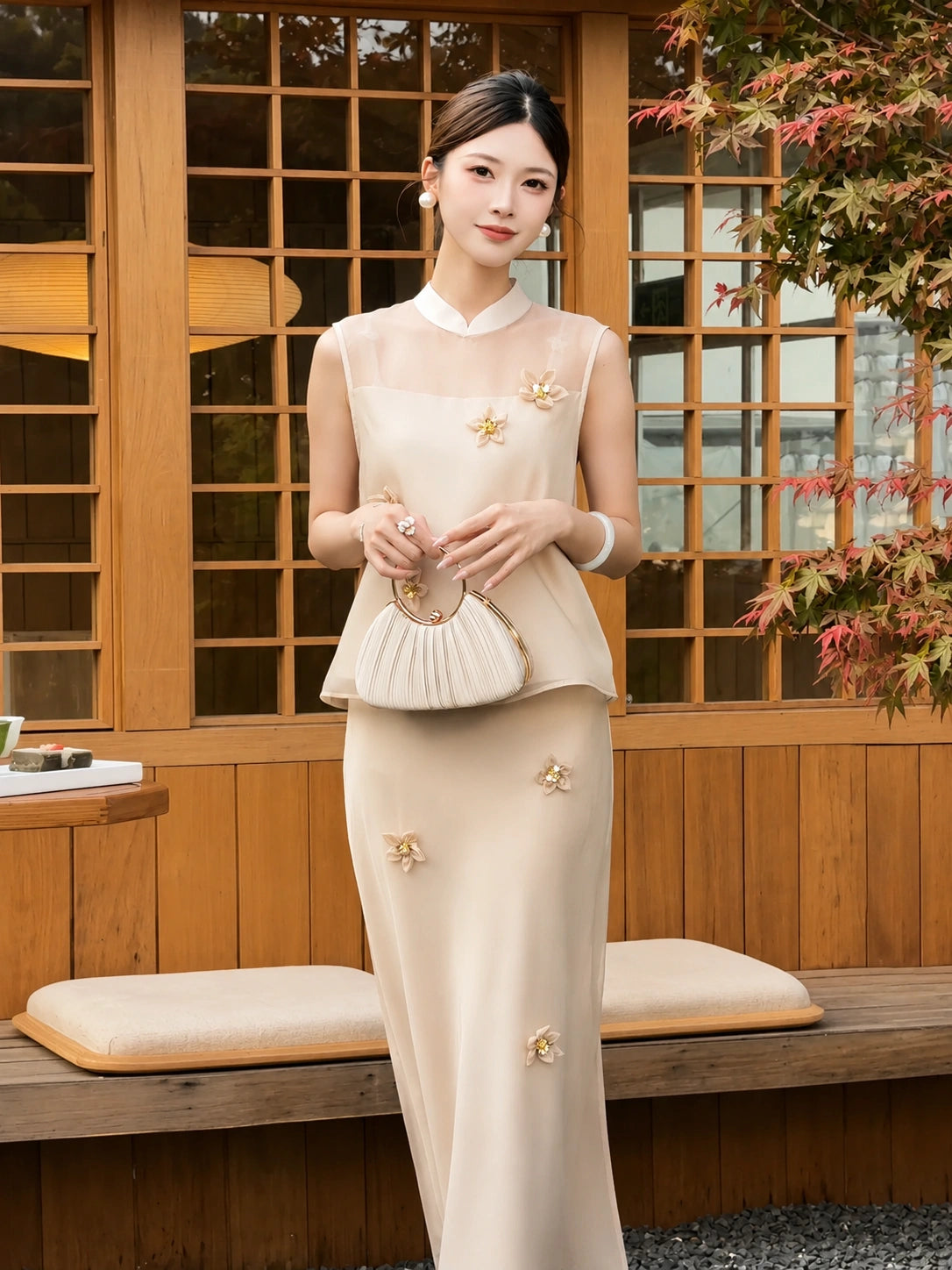 Model wearing a champagne sleeveless top with scattered flowers and matching skirt, sitting by a wooden window, showcasing the elegant Lyocell-Tencel blend.