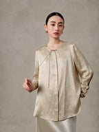 Front view of a champagne silk blend blouse with tie neckline