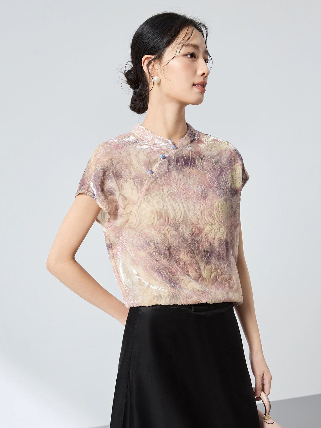 Side view of a champagne floral top with a stand collar, showcasing the elegant drape and shimmering texture of the 65.6% mulberry silk blend.