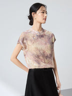 Side view of a champagne floral top with a stand collar, showcasing the elegant drape and shimmering texture of the 65.6% mulberry silk blend.
