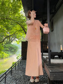 Side view of a champagne satin maxi skirt with a high waist, paired with an embroidered vest, highlighting the flattering A-line fit and comfortable drape.