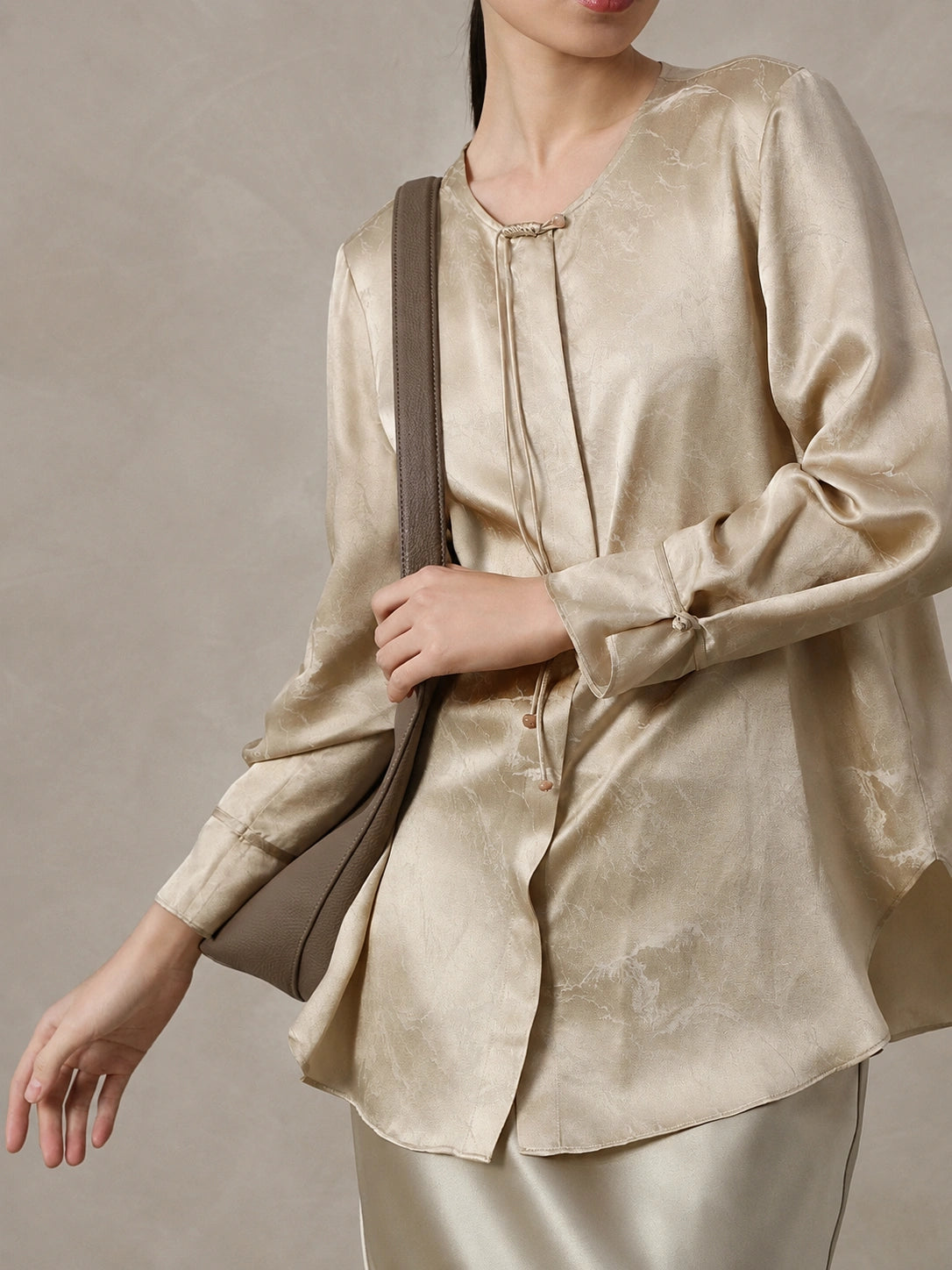 Side detail of a champagne jacquard silk blend blouse