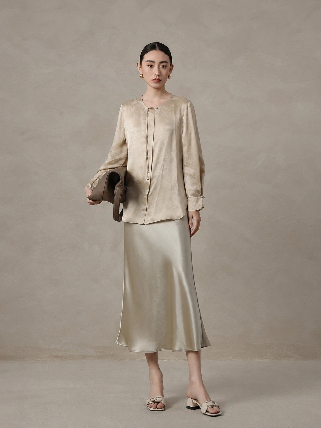 Woman wearing a champagne mulberry silk blend jacquard blouse