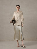 Woman wearing a champagne mulberry silk blend jacquard blouse