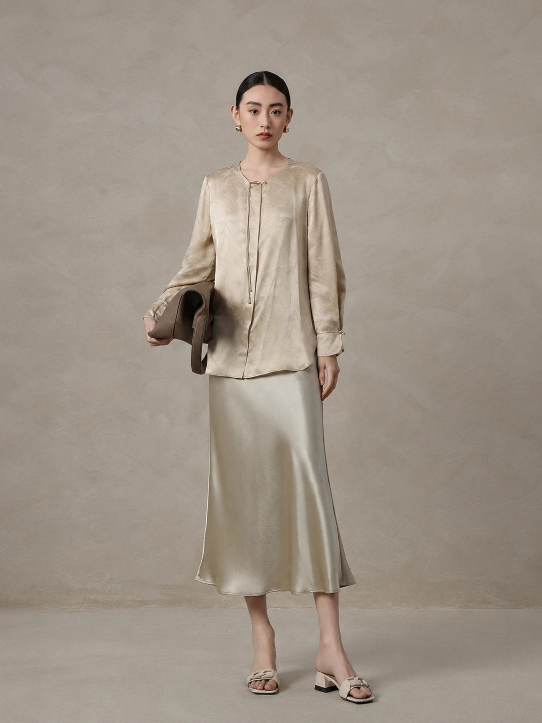 Woman wearing a champagne mulberry silk blend jacquard blouse