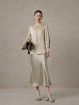 Woman wearing a champagne mulberry silk blend jacquard blouse