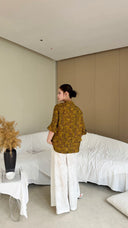 Back view of a New Chinese style Cheongsam top in olive green, featuring wool and viscose blend, paired with white wide-leg trousers.