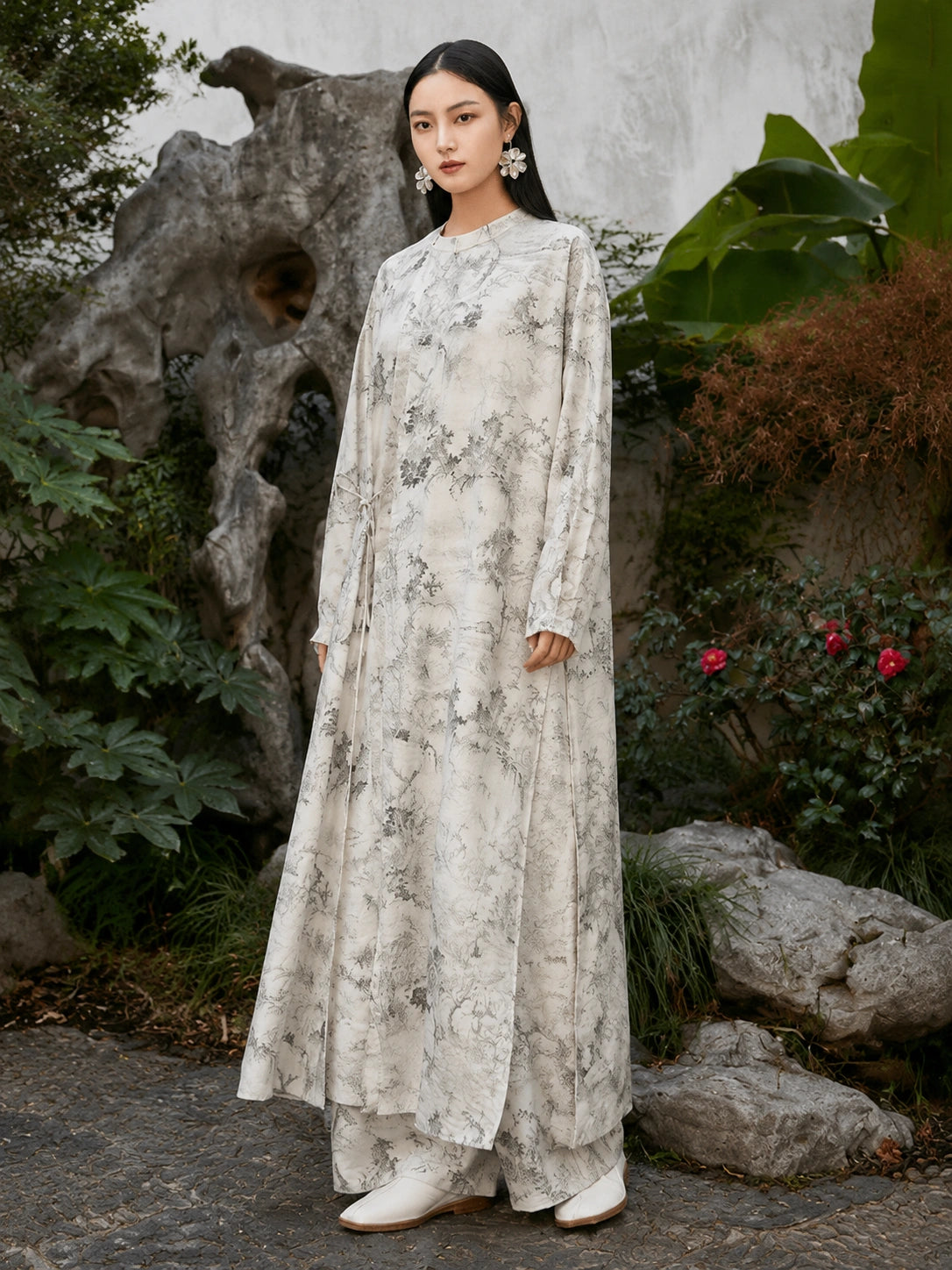 Three-quarter view of a flowing ivory Chinese ink landscape print maxi dress made from a premium viscose and acetate blend.