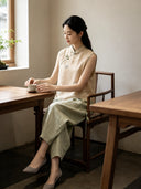 Chinese-inspired champagne yellow silk vest with floral embroidery worn in a traditional tea setting
