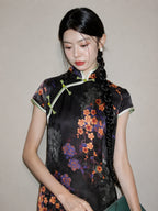 Upper-body close-up of a black floral rayon jacquard qipao with diagonal front closure, mandarin collar, and green piping.